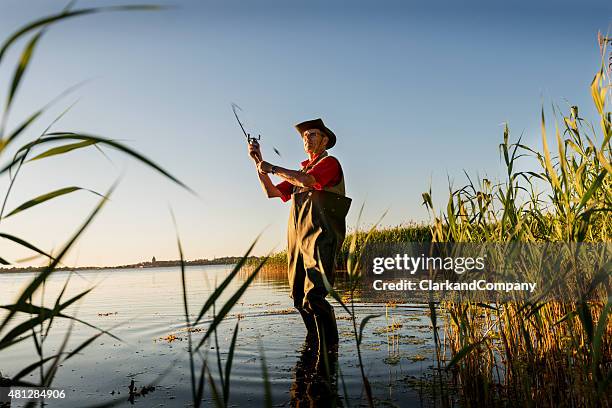 fischer mit schwimmer casting seinem line-out - angel stock-fotos und bilder