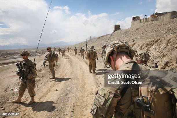 Soldiers with the U.S. Army's 2nd Battalion 87th Infantry Regiment, 3rd Brigade Combat Team, 10th Mountain Division patrol on the edge of a village...