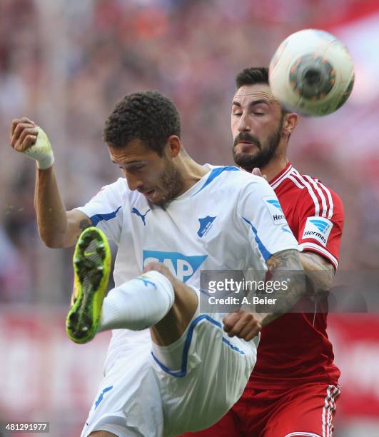 Diego Contento of Bayern Muenchen heads for the ball with Fabian Johnson of Hoffenheim during the Bundesliga match between FC Bayern Muenchen and...