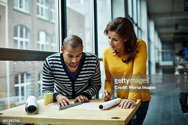 two architects discussing project at high table - architect stock pictures, royalty-free photos & images