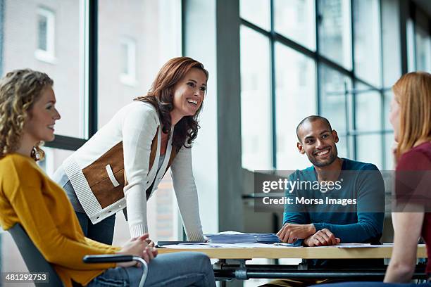 smiling coworkers in meeting - líder imagens e fotografias de stock