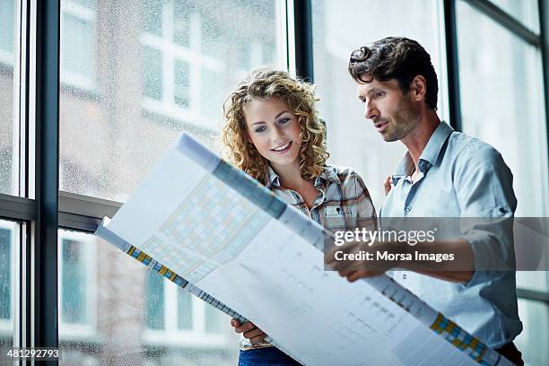 two architects checking blueprint - architekturberuf stock-fotos und bilder