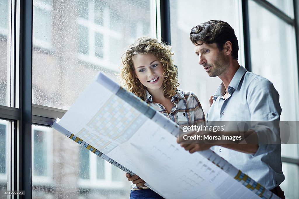 Two architects checking blueprint