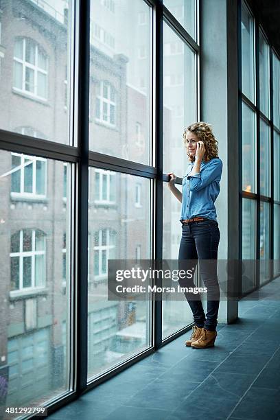 casually dressed business woman on the phone - business woman looking through window stock pictures, royalty-free photos & images