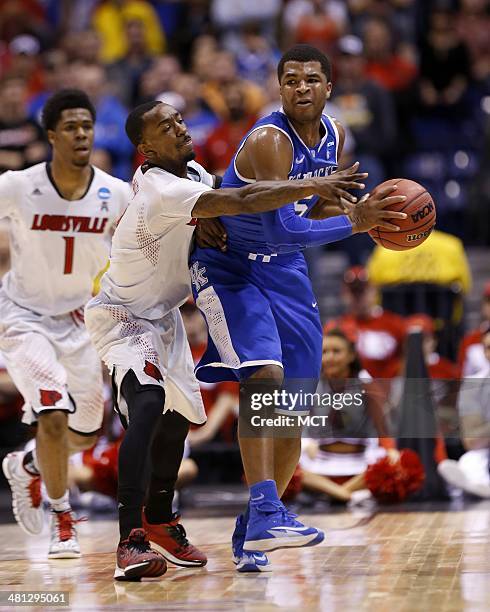 Kentucky Wildcats guard Andrew Harrison tries to get past Louisville Cardinals guard Russ Smith . Louisville takes on Kentucky in the NCAA Midwest...