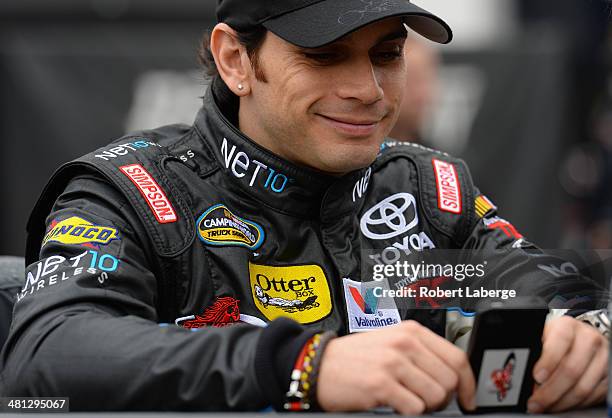 German Quiroga, driver of the NET10 Wireless Toyota, looks on on the grid during a rain delay in qualifying for the NASCAR Camping World Truck Series...