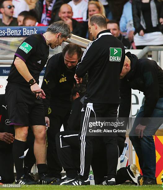 Injured referee Michael Weiner receives treatment during the Bundesliga match between VfB Stuttgart and Borussia Dortmund at Mercedes-Benz Arena on...