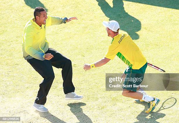 Nick Kyrgios of Australia runs on court to congratulate Lleyton Hewitt of Australia as he celebrates winning the reverse singles match between...