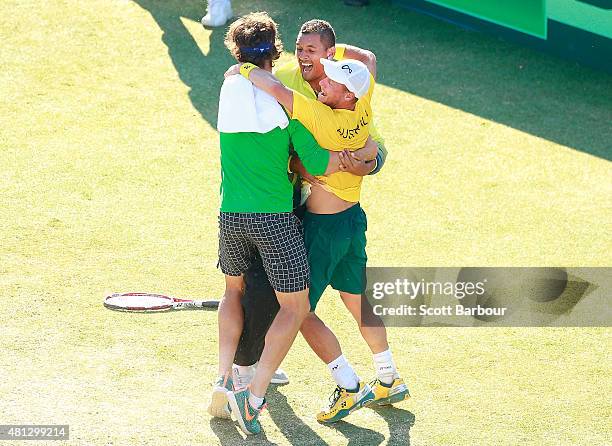 Thanasi Kokkinakis and Nick Kyrgios run on court to congratulate teammate Lleyton Hewitt of Australia as he celebrates winning the reverse singles...