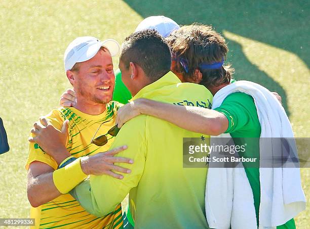 Sam Groth, Thanasi Kokkinakis and Nick Kyrgios run on court to congratulate teammate Lleyton Hewitt of Australia as he celebrates winning the reverse...