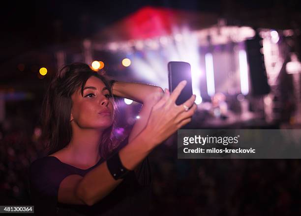 girl taking selfie at concert - spectator selfie stock pictures, royalty-free photos & images