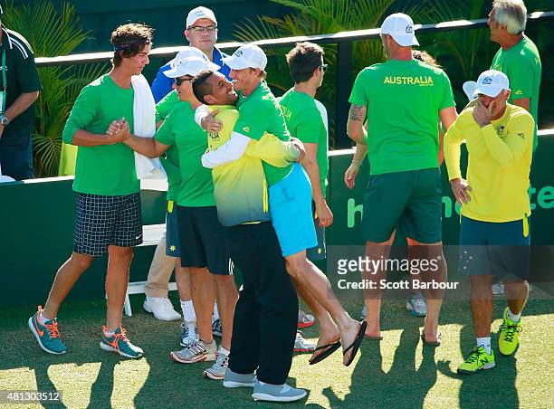 Nick Kyrgios hugs John Millman as the Australian team including Thanasi Kokkinakis and Sam Groth look on as teammate Lleyton Hewitt of Australia...