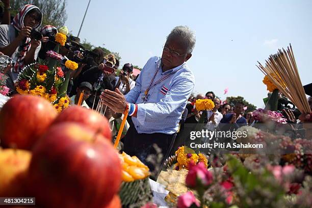 Anti-government leader, Suthep Thaugsuban, lights incense sticks during a ceremony at the Royal Plaza in Bangkok. Tens of thousands of...