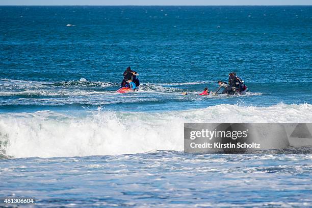 Mick Fanning and Julian Wilson climb to saftey after Fanning was attacked by a shark during the FInal of the JBay Open on July 19, 2015 in Jeffreys...