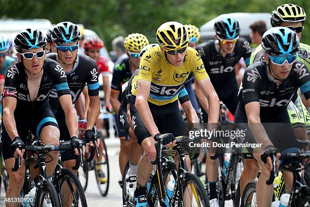 Chris Froome of Great Britain riding for Team Sky in the overall race leader yellow jersey rides in the protection of his teammates on the climb of...