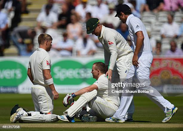 Chris Rogers of Australia is attended to by team-mates David Warner and Brad Haddin after a dizzy spell during day four of the 2nd Investec Ashes...