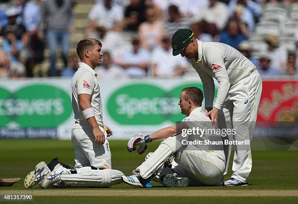 Chris Rogers of Australia is attended to by team-mates David Warner and Brad Haddin after a dizzy spell during day four of the 2nd Investec Ashes...