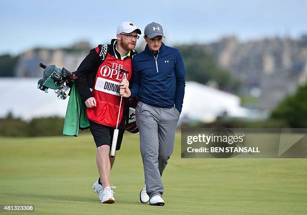 Ireland's amateur golfer Paul Dunne talks to his caddie Alan Murray as they walk up the 16th fairway during his third round 66, on day four of the...