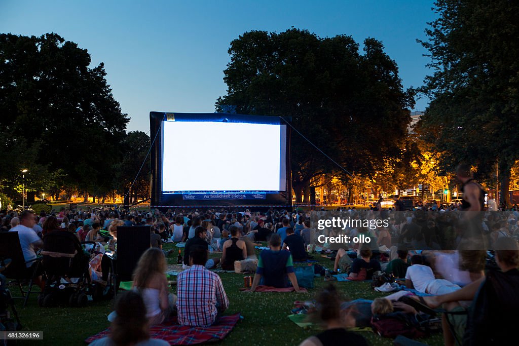 Os espectadores no cinema ao ar livre summer noite