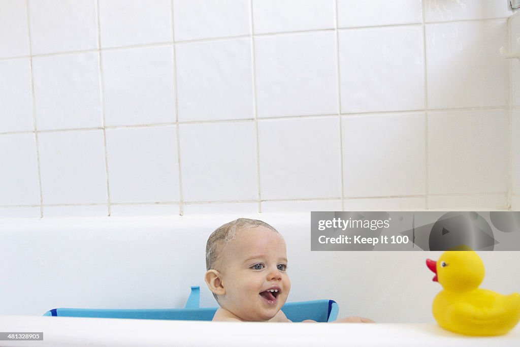 Baby boy smiling at rubber duck