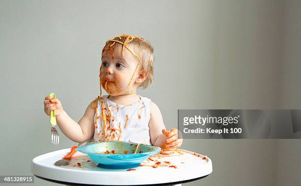 baby boy getting messy eating spaghetti - funny baby faces stock pictures, royalty-free photos & images