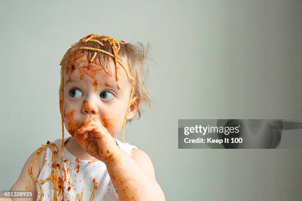 baby boy getting messy eating spaghetti - baby head in hands stock pictures, royalty-free photos & images