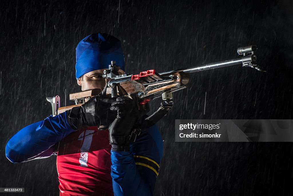 Athletic man with biathlon rifle