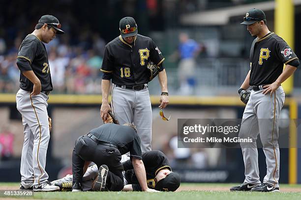 Jordy Mercer of the Pittsburgh Pirates holds his leg after a collision with Carlos Gomez of the Milwaukee Brewers during the second inning at Miller...