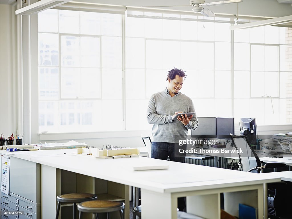 Smiling businessman working on digital tablet