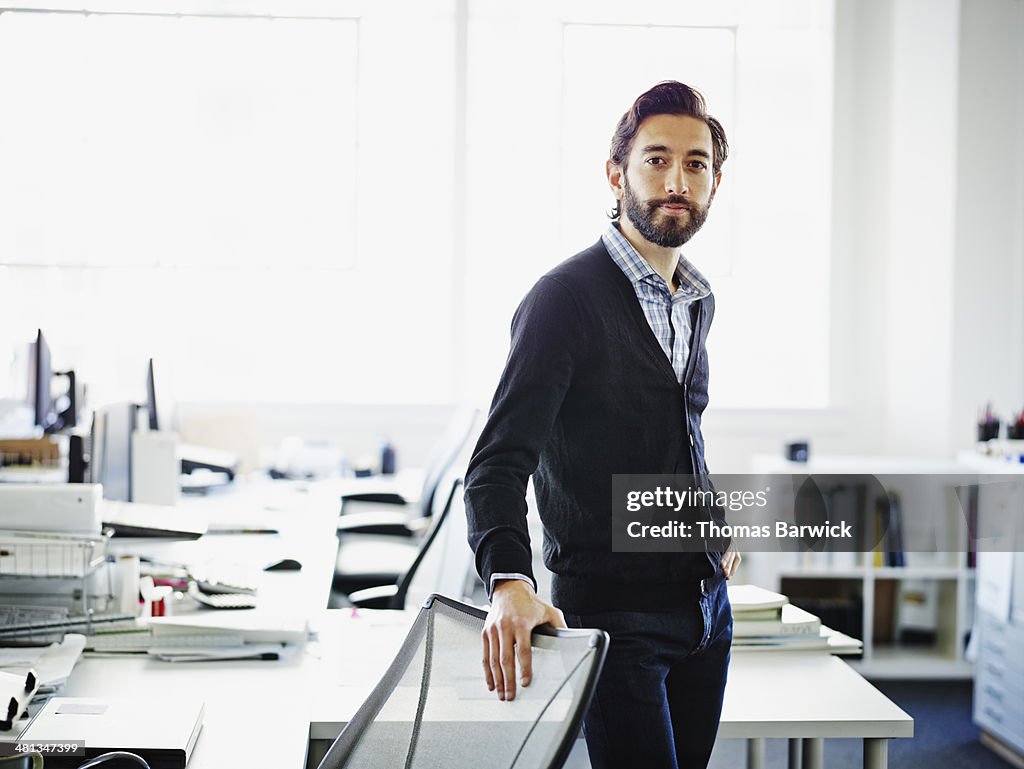 Smiling professional standing at workstation