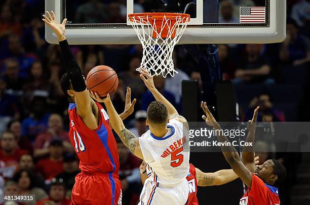 Scottie Wilbekin of the Florida Gators goes to the basket as Devon Scott of the Dayton Flyers defends during the south regional final of the 2014...