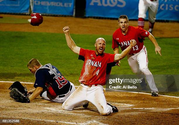 Peter Orr of Canada celebrates scoring the winning run in the tenth inning as Thomas Murphy of the USA and Tyler O'Neill of Canada looks after their...