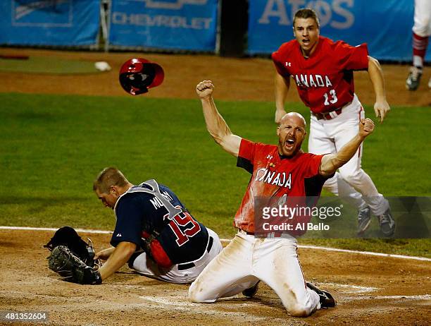 Peter Orr of Canada celebrates scoring the winning run in the tenth inning as Thomas Murphy of the USA and Tyler O'Neill of Canada looks after their...