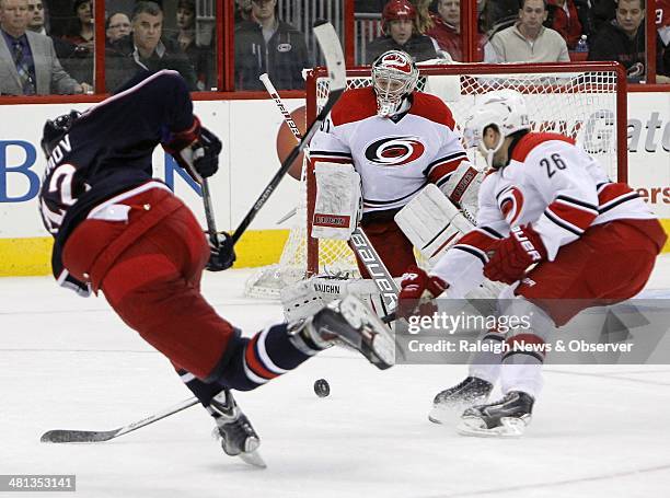 The Carolina Hurricane4s' Anton Khudobin and John-Michael Liles defend a shot by the Columbus Blue Jackets' Artem Anisimov in the first period at PNC...