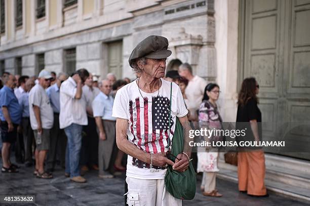 People wait outside of a bank in central Athens, prior to its opening on July 20, 2015. Greek banks reopened Monday after a three-week shutdown...