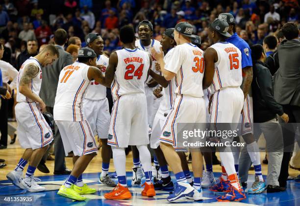 The Florida Gators celebrate on the court after defeating the Dayton Flyers 62-52 in the south regional final of the 2014 NCAA Men's Basketball...
