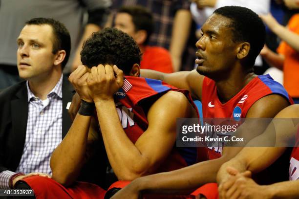 Devin Oliver and Dyshawn Pierre of the Dayton Flyers react on the bench after losing to the Florida Gators 62-52 in the south regional final of the...
