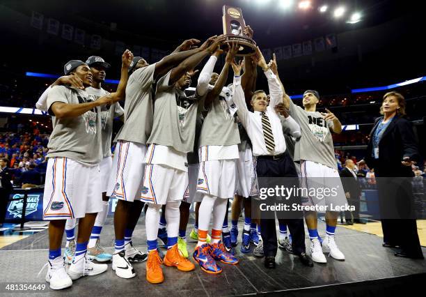 The Florida Gators celebrate with the trophy after defeating the Dayton Flyers 62-52 in the south regional final of the 2014 NCAA Men's Basketball...