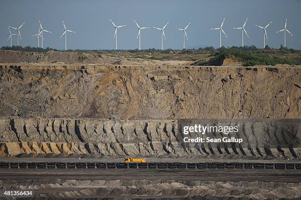 Truck drives through the Welzow Sued open-pit lignite coal mine as wind turbines spin nearby on July 9, 2015 near Welzow, Germany. The Welzow Sued...