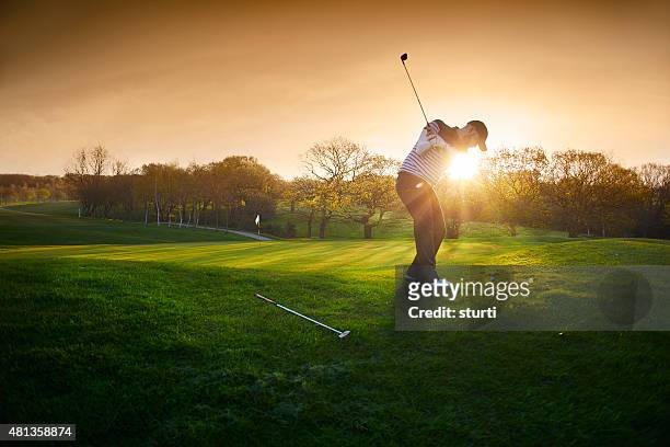 backlit golf course with golfer chipping onto green - golf club stock pictures, royalty-free photos & images