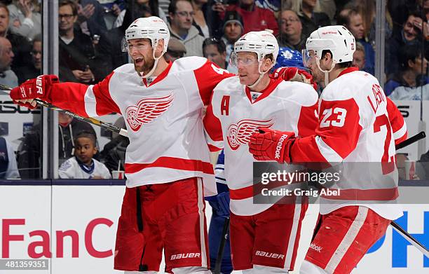 Jakub Kindl, Daniel Alfredsson and Brian Lashoff of the Detroit Red Wings celebrate a second period goal during NHL game action against of the...