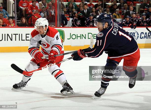 Matt Calvert of the Columbus Blue Jackets releases a shot while being defended by Andrei Loktionov of the Carolina Hurricanes during their NHL game...