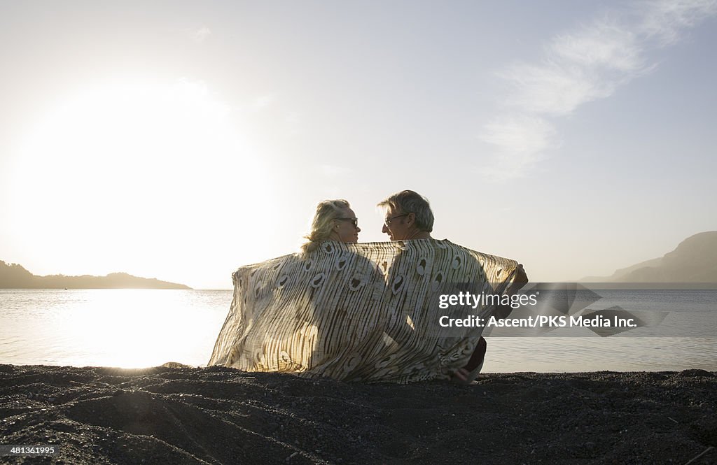 Couple wrap themselves in sarong, at beach