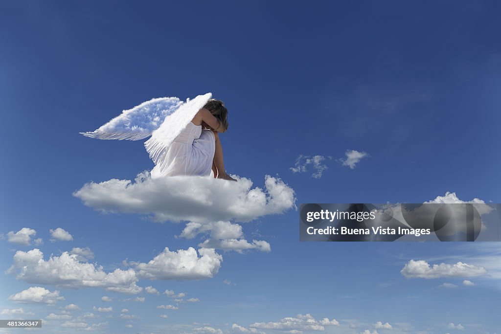 Woman with angel's wings on a cloud