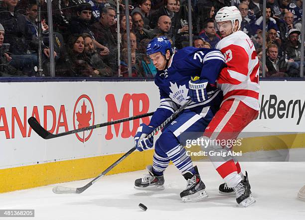 David Clarkson of the Toronto Maple Leafs battles for the puck with Brian Lashoff of the Detroit Red Wings during NHL game action March 29, 2014 at...