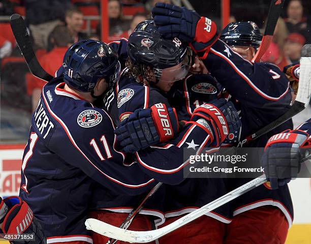 Matt Calvert and Jack Johnson of the Columbus Blue Jackets surround Ryan Johansen following his overtime, game-winning goal against the Carolina...