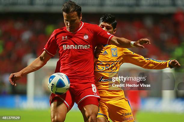 Aaron Galindo of Toluca struggles for the ball with Alan Pulido of Tigres during a match between Toluca and Tigres UANL as part of the 13th round of...