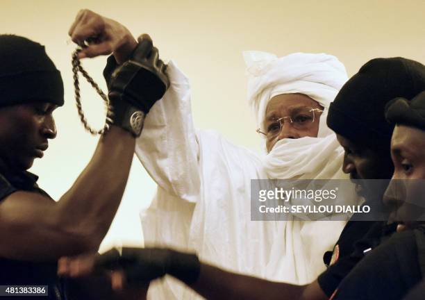 Former Chadian dictator Hissene Habre is escorted by prison guards into the courtroom for the first proceedings of his trial by the Extraordinary...