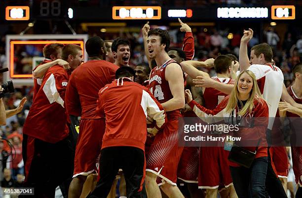 Frank Kaminsky of the Wisconsin Badgers celebrates with teammates after defeating the Arizona Wildcats 64-63 in overtime during the West Regional...