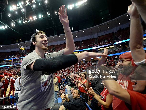 Frank Kaminsky of the Wisconsin Badgers celebrates with fans defeating the Arizona Wildcats 64-63 in overtime during the West Regional Final of the...